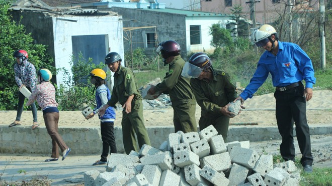 Tuyển chọn Công an xã: Tối thiểu tốt nghiệp tiểu học! Công an xã Quảng Trạch, Quảng Bình cùng dân xếp gạch làm đường. Ảnh: Hồng Vĩnh
