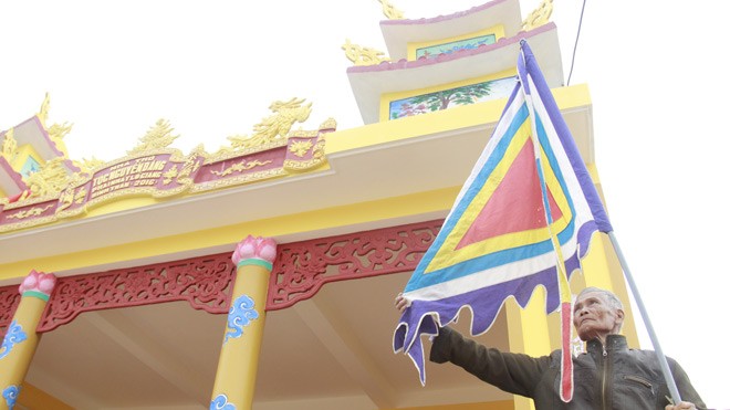 “Phố nhà tộc” rộn ràng đón Tết Ông Nguyễn Đăng Thiện (87 tuổi, tộc Nguyễn Đăng) treo lá cờ trước ngôi nhà thờ vừa được sơn mới của dòng họ Nguyễn Đăng. Ảnh :Thanh Trần