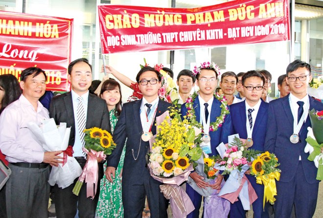 Chủ nhân 2 HCV Olympic Hóa: Trí tuệ người trẻ là tài nguyên đất nước Ðức Anh (đứng thứ 3 từ trái sang) cùng với đội tuyển Hóa tại lễ đón đoàn. Ảnh: Nghiêm Huê.