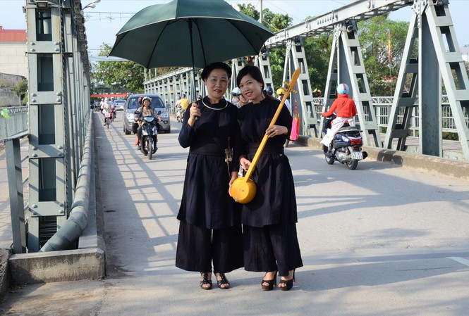'Pây Tái' báo hiếu ở xứ Lạng Bà Kiệm (bìa trái, cầm ô) trên đường về quê thăm, hiếu lễ với bố mẹ. Ảnh: Duy Chiến