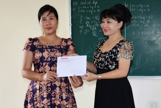 Báo Tiền Phong giúp đỡ trò nghèo vùng sâu Ea Súp Cô Hồng Phượng (bên trái) nhận tiền hỗ trợ bữa ăn cho trò nghèo từ đại diện báo Tiền Phong