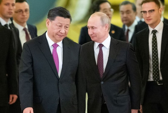 Cùng đối đầu Mỹ, Nga - Trung tìm đến nhau Tổng thống Nga Vladimir Putin và Chủ tịch Trung Quốc Tập Cận Bình sánh bước trong cuộc gặp tại Kremlin hôm 5/6. Ảnh: Reuters