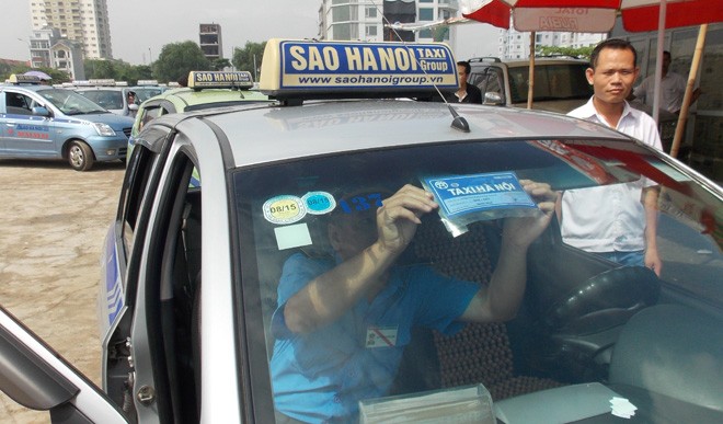 Vì sao giá xăng giảm mạnh nhiều lần, cước taxi bất động? Doanh nghiệp taxi cho biết, mỗi lần điều chỉnh giá cước mỗi taxi còn phải thay tem nhãn báo giá, đồng hồ cước mất ít nhất 1 ngày. ảnh: A. Trọng