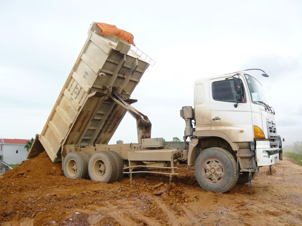 Chuyện dự án đội vốn 1.200 tỷ đồng Xe tải của Cty Xuân Thành đổ đất trên đê tả sông Hồng đoạn qua huyện Khoái Châu (Ảnh chụp ngày 25-5-2012)