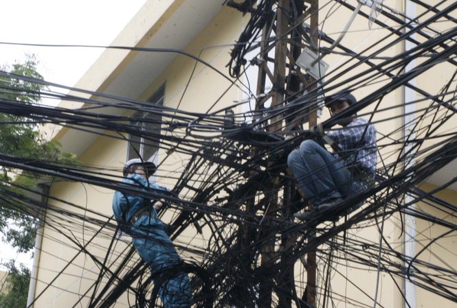Người ‘nhện’ lơ lửng trên dây điện Cáp điện chằng chịt vừa mất mỹ quan vừa nguy hiểm cho người tham gia giao thông trong mùa mưa bão