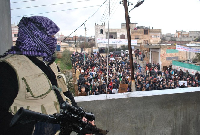 Thủ lĩnh al-Qaeda ủng hộ cách mạng Syria Biểu tình chống chế độ Assad ở thành phố Homs (hai người cầm súng là lính
chính phủ đào ngũ) Ảnh: Mint Press