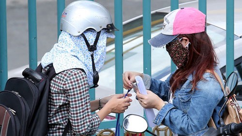 Công khai thi hộ, giao dịch qua Facebook Sinh viên H.N (phải) gửi thẻ sinh viên nhờ phóng viên thi hộ ngay trước cổng trường - Ảnh: Đào Ngọc Thạch