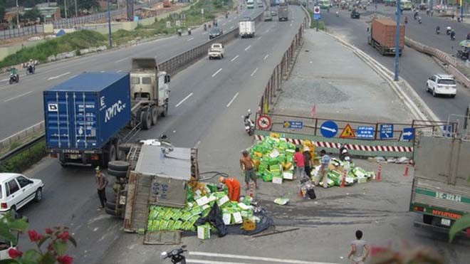 Xe tải lật nghiêng, 2 thanh niên lao vào 'hôi của' Hiện trường sự cố lật xe chở nước ngọt