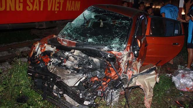 Tàu hỏa tông nát ô tô, dân đập kính đưa 4 người đi viện Chiếc xe 4 chỗ bị tàu hỏa đâm nát bét phần đầu.