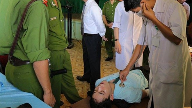 Sát thủ ngất xỉu trước vành móng ngựa Bảo được cán bộ y tế cấp cứu. Ảnh: Hoàng Táo