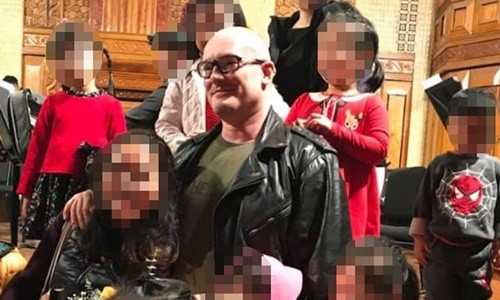Quá khứ ấu dâm của nhạc công Anh trước khi đến Việt Nam biểu diễn Christopher Trinnaman chụp ảnh với trẻ em Việt Nam năm 2018. Ảnh: Mirror.