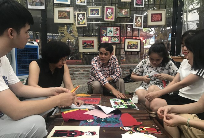 Thắp ước mơ từ vải vụn Anh Lê Việt Cường (áo sọc) và họa sĩ Đặng Thị Khuê (áo đen) hướng dẫn các bạn trẻ khuyết tật làm tranh ảnh Nhã Khanh