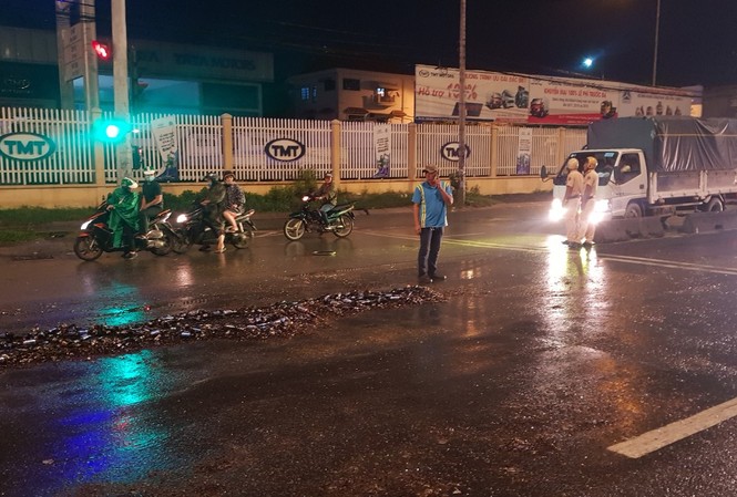 CSGT thu dọn hàng trăm chai bia đổ vỡ trên quốc lộ 1 Hiện trường vụ việc.