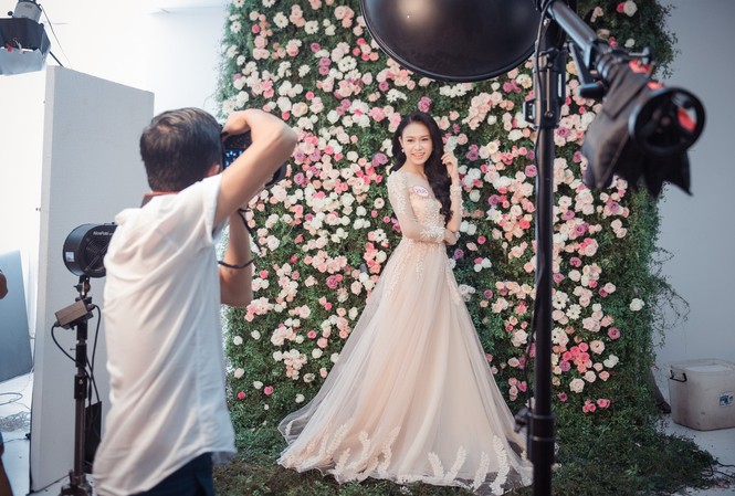 Bức tường ngàn hoa làm nền cho thí sinh HHVN Nhiếp ảnh gia Lê Thiện Viễn chụp hình cho thí sinh Phùng Bảo Ngọc Vân.