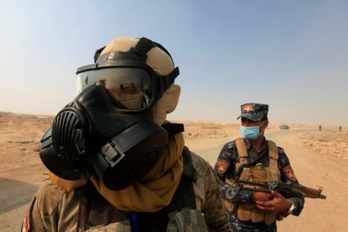 Lính Mỹ đeo mặt nạ phòng khí độc chống IS ở Iraq Lực lượng Iraq đeo mặt nạ bảo vệ tại Qayyara, sau khi gió thổi khí độc từ nhà máy sulphur bị IS đốt cháy. Ảnh: Reuters