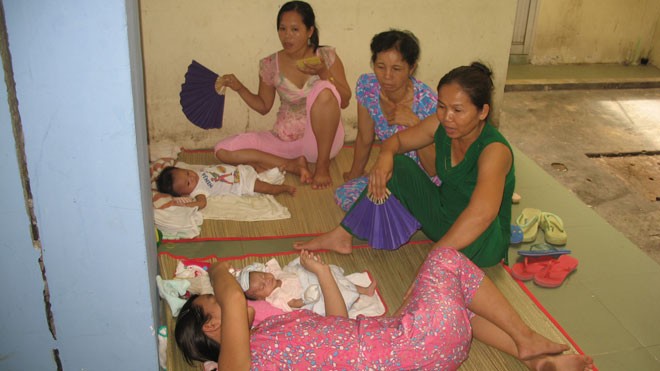 Vào “mùa” bệnh bủa vây Không còn chỗ nằm, nhiều bà mẹ bế con ra hành lang để nằm. ảnh: L.N