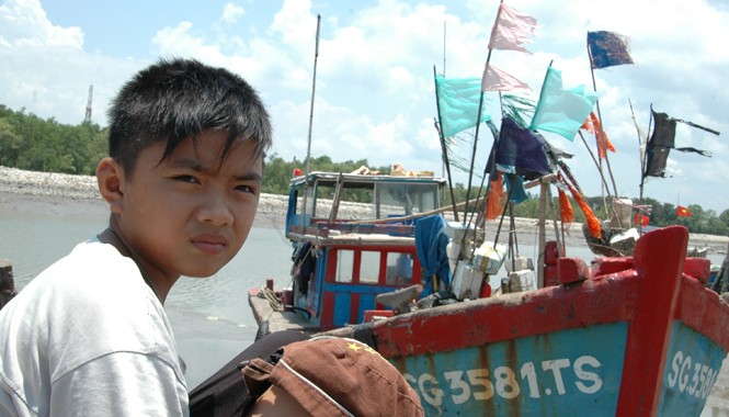 Đâu rồi những đội tàu vươn khơi Cảng cá đìu hiu. Bé Đỗ 13 tuổi không biết chữ đang đợi bố đánh cá trở về. Ảnh: T.N.A