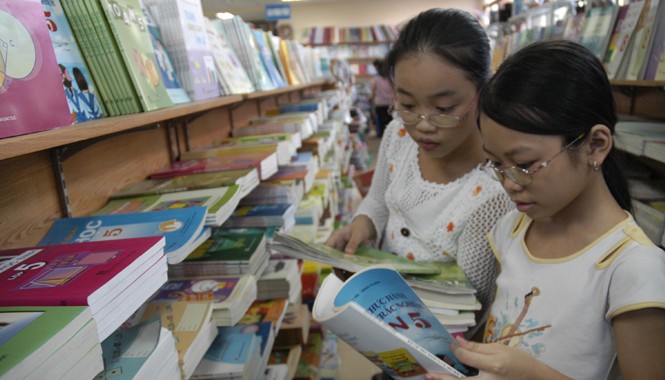 Chương trình - SGK sau 2015: Có thể triển khai đồng loạt với cấp tiểu học Học sinh tiểu học lựa chọn sách giáo khoa tại một cửa hàng sách trên đường Lý Thường Kiệt (Hà Nội). Ảnh: Hồng Vĩnh
