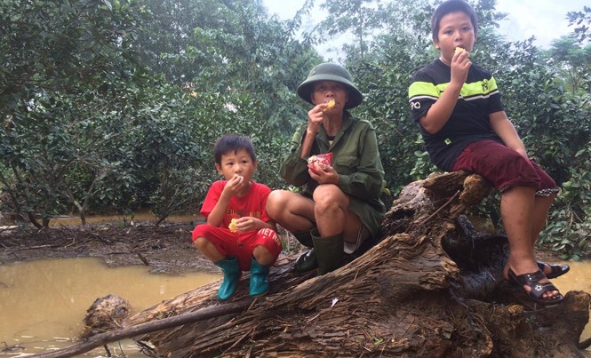 Những bữa cơm ám ảnh tại vùng rốn lũ Hà Tĩnh Bà Nhiệm cùng với hai cháu nội cầm hơi trong 3 ngày lũ bằng mì tôm và nước suối hàng xóm tiếp tế. Ảnh: Bá Hải.