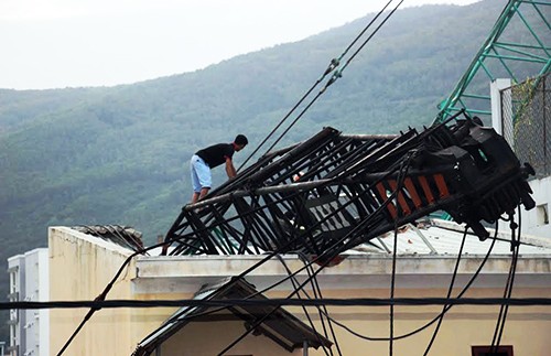 Vợ chồng cụ ông 92 tuổi tháo chạy khi cần cẩu đè mái nhà Cần cẩu công trình đè lên mái nhà bên cạnh. Ảnh: Quy Nhơn.