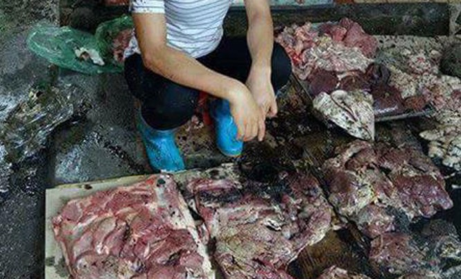 Bản tin 8H: Bán thịt lợn giá rẻ, người phụ nữ bị đổ chất bẩn vào người Chị Xuyến cùng khoảng 50kg thịt lợn bị hắt dầu luyn trộn với chất thải. Ảnh cắt từ video.