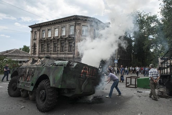 Bản tin 20H: Mỹ tố Nga gửi vũ khí cho miền đông Ukraine Một chiếc xe quân sự bị đốt sau cuộc đụng độ giữa quân đội Ukraine và phe ly khai ở Mariupol ngày 13/6 (Nguồn: AP)