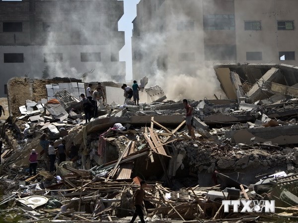 Bản tin 14H: Israel tiếp tục không kích Gaza Một chung cư 12 tầng bị sập sau vụ không kích của Israel xuống thành phố Gaza ngày 24/8. (Nguồn: AFP/TTXVN)