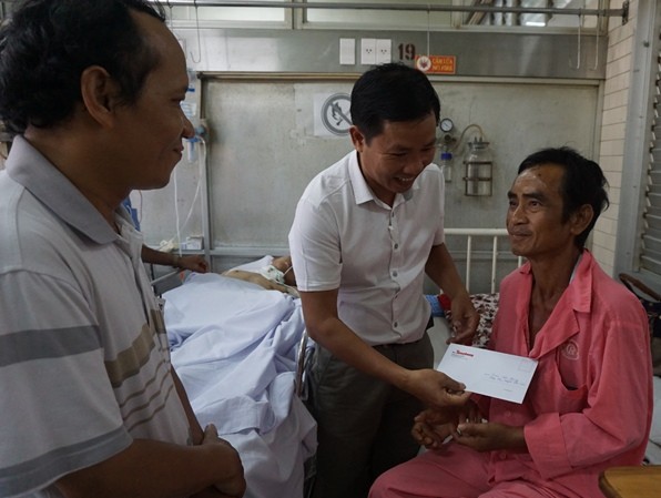 Sức khỏe ông Nén hồi phục tốt Từ trái qua: Nhà báo Nguyễn Đình Quân, nhà báo Đại Dương - Phó Bí thư chi bộ Cơ quan đại diện Báo Tiền Phong tại TPHCM trao quà động viên ông Nén tại Bệnh viện Chợ Rẫy chiều 25/3. Ảnh: Quốc Ngọc