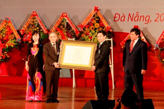Công nhận ĐH Duy Tân đạt tiêu chuẩn chất lượng giáo dục Nhà giáo ưu tú Lê Công Cơ, Hiệu trưởng trường ĐH Duy Tân (bìa trái) vinh dự đón nhận Giấy chứng nhận KĐCLGD cho nhà trường. Ảnh: Thanh Trần.