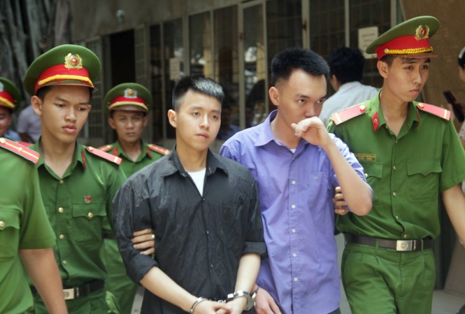 Cụ bà 71 tuổi thuê người bắn 'tình trẻ' ở Sài Gòn bị tuyên 3 năm tù treo Dẫn giải hai bị cáo Nhân, Quang về trại giam sau phiên tòa. Ảnh: Tân Châu