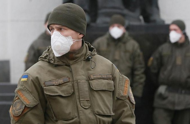 Sợ Covid-19, tội phạm Ukraine cướp cả khẩu trang Lực lượng vệ binh Ukraine đeo khẩu trang khi đứng làm nhiệm vụ trước tòa nhà quốc hội ở Kiev. (Ảnh: AP)