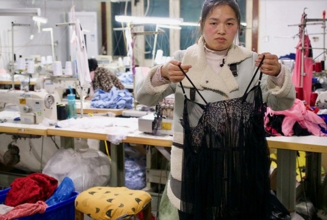 Làng lúa đổi đời nhờ nghề... may đồ lót Chị Chen Haili bên chiếc áo ngủ vừa may xong. (Ảnh: SCMP)