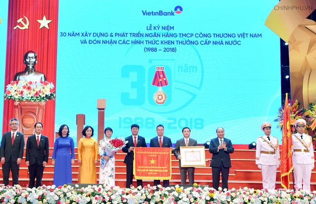 Thủ tướng: 'VietinBank phải tận dụng mọi thời cơ, thách thức' Thay mặt lãnh đạo Đảng, Nhà nước, Thủ tướng đã trao Huân chương lao động Hạng Nhất, Cờ thi đua của Chính phủ cho Vietinbank. Ảnh VGP/Quang Hiếu