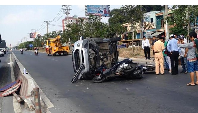 Ô tô 'bay' qua dải phân cách tông 3 xe máy rồi lật ngang đường Lực lượng chức năng điều tra vụ việc.