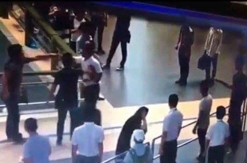 Người 'giải cứu' nữ nhân viên hàng không có bị xử phạt hành vi gây rối? Người đàn ông (áo đen ngoài cùng bênn trái) đã giải cứu nữ nhân viên hàng không. Ảnh cắt từ clip.