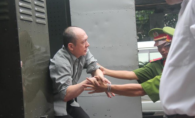 Hy hữu từ phiên tòa xử vụ dùng xăng đốt chết người tình Dẫn giải bị cáo Nguyễn Ngọc Sơn đến phiên tòa lưu động. Ảnh: Tân Châu.