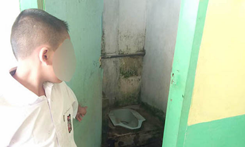 Kinh hoàng, giáo viên phạt học sinh liếm bồn cầu vì quên làm bài tập MB chỉ vào chiếc bồn cầu bị cô giáo phạt. Ảnh: Metro24jam
