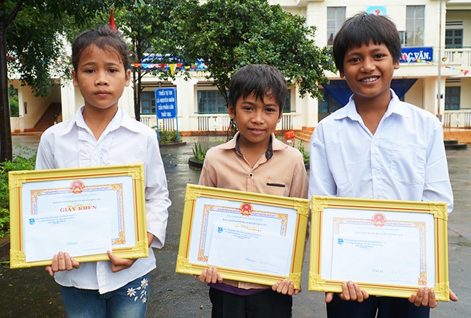Ba học sinh tiểu học cứu bé gái đuối nước Túy (từ trái), Khang và Thứ nhận bằng khen sáng 7/9. Ảnh: Trần Hóa.