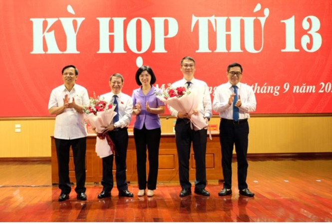Ông Hoàng Anh Tuấn được bầu làm Chủ tịch UBND huyện Mê Linh Phó Chủ tịch HĐND thành phố Phùng Thị Hồng Hà tặng hoa chúc mừng các đồng chí lãnh đạo huyện Mê Linh. Ảnh: Hoàng Sơn.