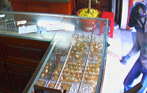 TP HCM: Kẻ cướp đập tủ kính, gom vàng trong 5 giây Tên cướp dùng búa đẽo đập vỡ tủ kính hốt đi nhiều nữ trang. Ảnh: Trích từ camera tiệm vàng