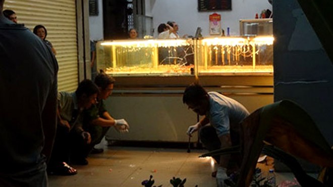 Chân dung 2 nghi can dùng súng cướp tiệm vàng ở Bình Dương Cơ quan công tiến hành khám nghiệm hiện trường. Ảnh: Thanh Niên