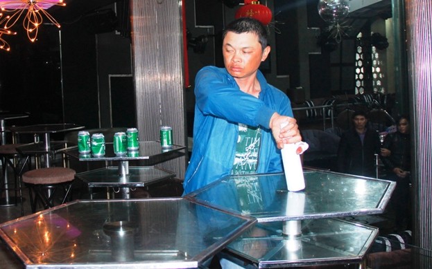 Dùng chai bia vỡ đâm chết người trong vũ trường Hoàng Công Thuật diễn tả lại hành động đập chai bia vào đầu người bảo vệ và đâm Huỳnh Quý. Ảnh: Công an Nhân dân