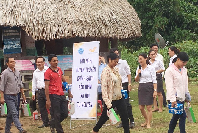 Mồ hôi ướt đẫm nhưng nụ cười vẫn rạng rỡ trên môi Tuyên truyền viên Trần Thị Mai Phương chân đất, mải mê tư vấn cho bà con đồng bào Cơ Tu. Ảnh: An Phú
