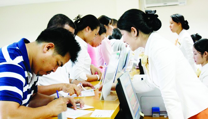 Khi người vay tiền bị... “săn lùng” Một giao dịch tại ngân hàng. Ảnh: hồng vĩnh