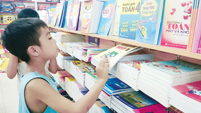 Rối bời đổi mới chương trình, SGK Một học sinh đang tìm chọn sách giáo khoa cho năm học mới. Ảnh: Ngọc Châu