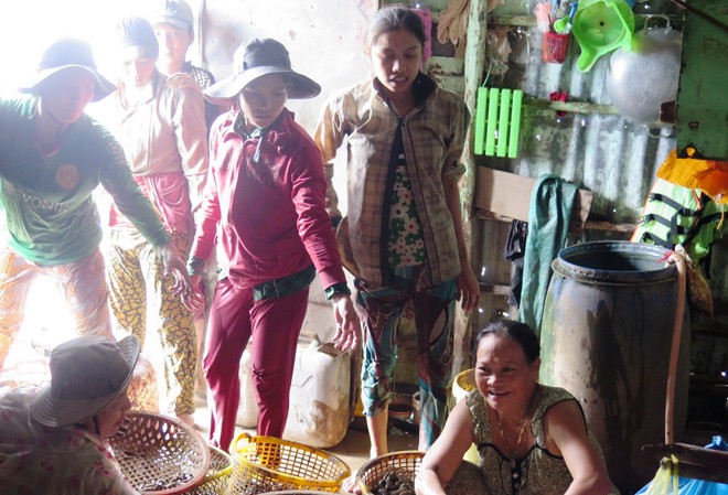 Bà Ba Bánh tét với “tập đoàn hái lượm” Bà Ba Bánh tét (ngồi bên phải) tươi cười mua sản vật hái lượm. Ảnh: Tiến Hưng