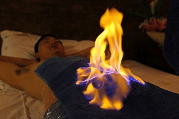 Kỳ bí phương pháp chữa bệnh bằng... lửa Người bệnh cảm thấy rất thoải mái khi ngọn lửa cháy trên người. (Nguồn: CCTV)