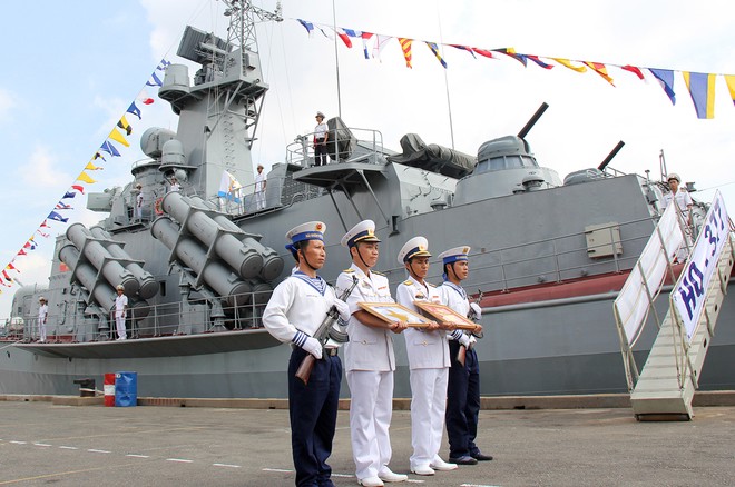 Bản tin 14H: Thượng cờ hai tàu pháo tên lửa đầu tiên do Việt Nam đóng Thuyền trưởng, Chính trị viên Tàu HQ-377 chuẩn bị lên tàu kéo cờ. Ảnh: VnExpress