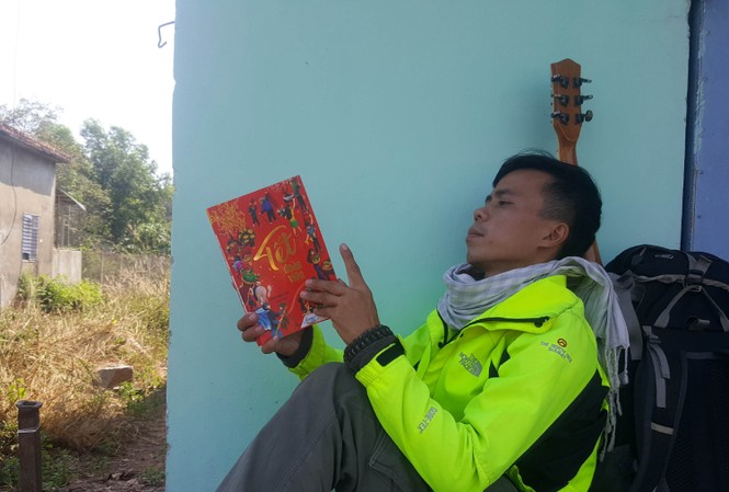 Chàng trai đi bộ 400 km về quê ăn Tết Hồ Nhật Hà trong ngôi nhà bỏ không tình cờ gặp ở Bình Phước, với hành trang là sách, đàn ghi ta, bên cạnh một ba lô các thứ thiết yếu. Ảnh: Nhân vật cung cấp.