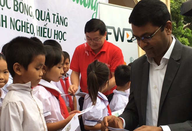 Trao học bổng 'Nâng bước em tới trường' Ông Anantha (bìa phải) và ông Lê Xuân Sơn trao học bổng cho học sinh tại buổi lễ.